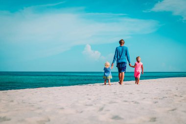 Baba ile iki küçük kızı Sahilde yürüyüş