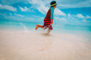 küçük çocuk kumsalda sıçramasına su çalıştırmak