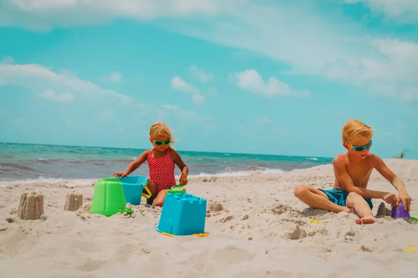 Mignon garçon et fille jouer avec sable sur la plage — Photo