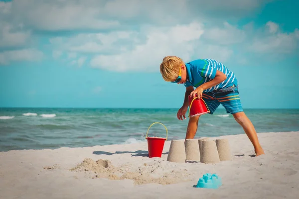 Roztomilý chlapec hrát s pískem na moři, kid budování hradu na tropické pláži — Stock fotografie