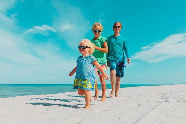 Gelukkig vader met kinderen lopen op strand — Stockfoto