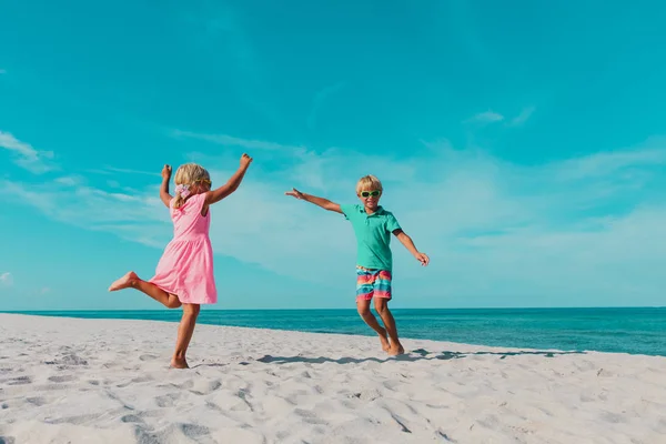 Мальчик и девочка танцуют на пляже, дети наслаждаются отдыхом на море — стоковое фото