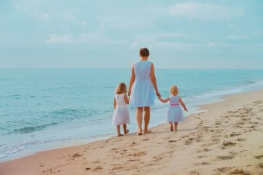 Sahilde küçük kızları yürüyüş ile anne