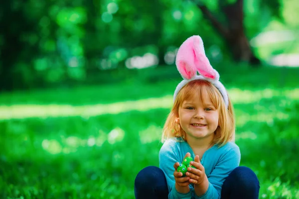 Feliz linda niña en la caza de huevos de Pascua en primavera — Foto de Stock