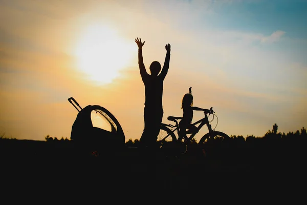 Щасливі батько і дочка катаються на велосипеді на заході сонця — стокове фото