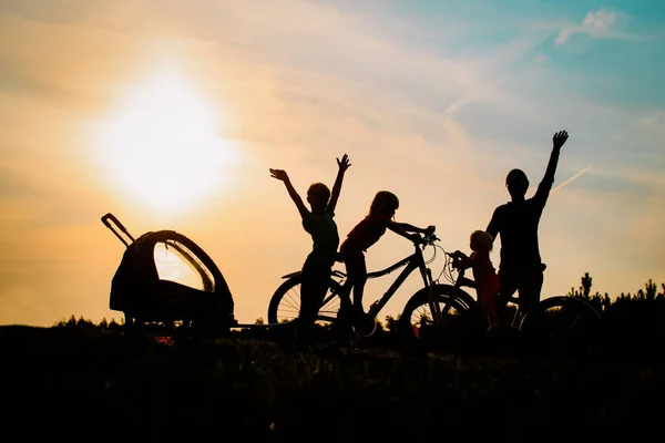 Щасливий тато з дітьми катається на велосипеді на заході сонця — стокове фото