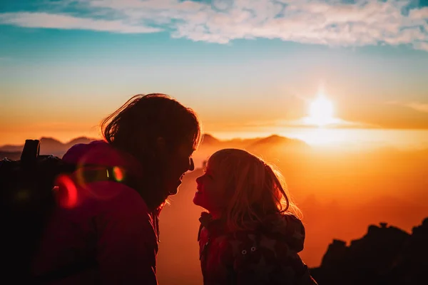 Matka a dcera malá cestovat v západu slunce horách, rodinná silueta — Stock fotografie