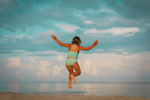 Felice bambina godere della spiaggia, bambino saltare in vacanza al mare — Foto Stock
