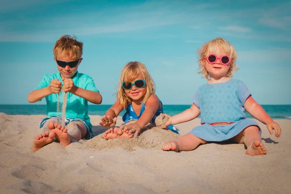 Roztomilý chlapec a dívky hrát na pláži — Stock fotografie