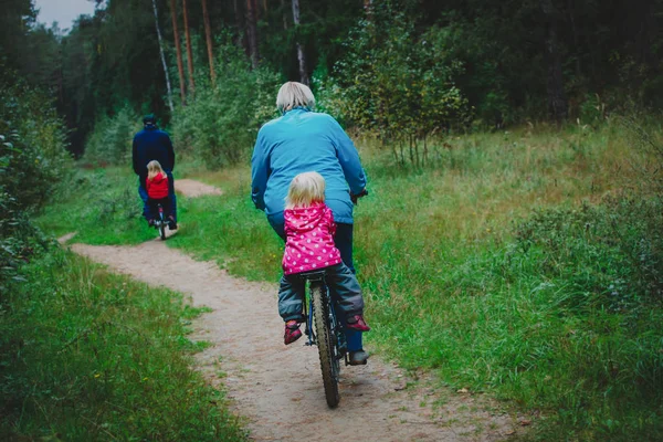 Aktiva äldre morföräldrar med barn ridning cyklar i naturen — Stockfoto