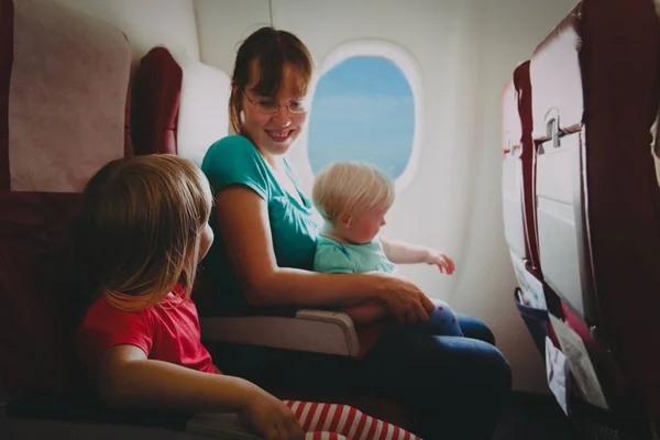 Madre con dos hijos viajan en avión — Foto de Stock