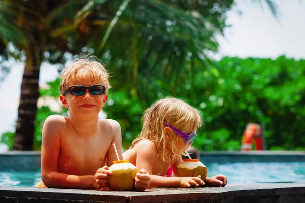 Lindo feliz niños - niño y niña - beber cóctel de coco en el complejo de playa — Foto de Stock