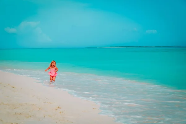 Feliz linda niña jugar con olas en la playa —  Fotos de Stock