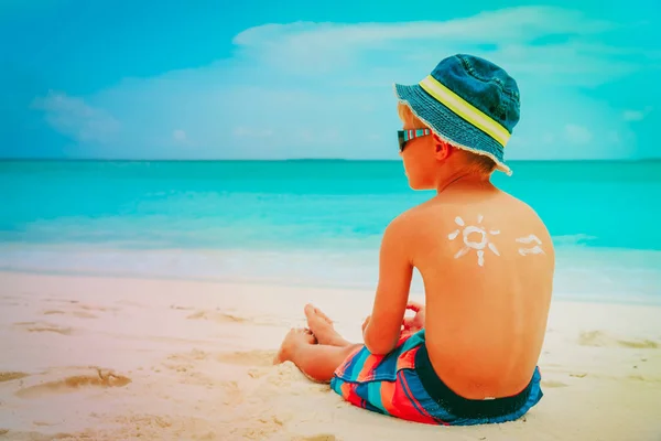 Protezione solare- bambino con crema solare in spiaggia — Foto Stock