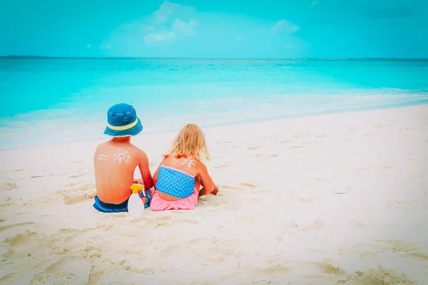 Sun protection - mały chłopiec i dziewczynka z suncream Beach — Zdjęcie stockowe