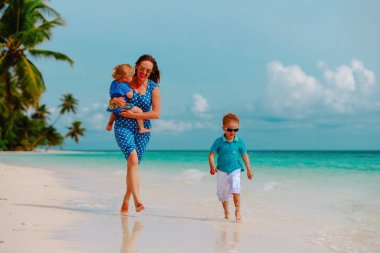 Anne çocuklarla oynamak üzerinde çalışma tropikal plaj