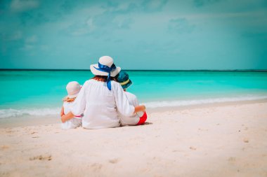 Sahilde oğul ve kızı sarılmak ile mutlu anne
