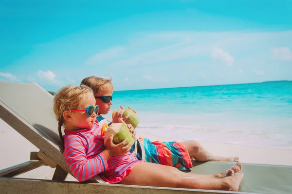 Bambino e ragazza bere cocco in vacanza al mare — Foto Stock