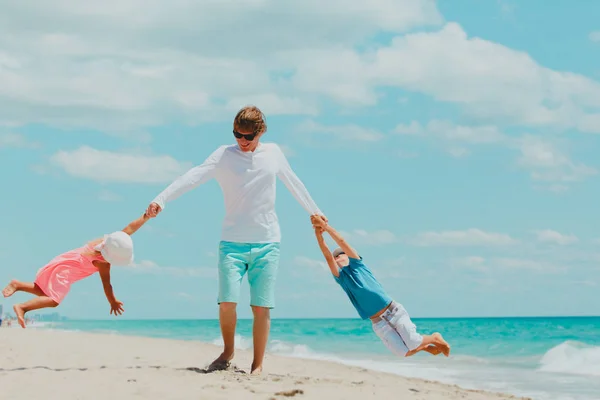 Gelukkige vader met zoon en dochter te spelen op het strand — Stockfoto