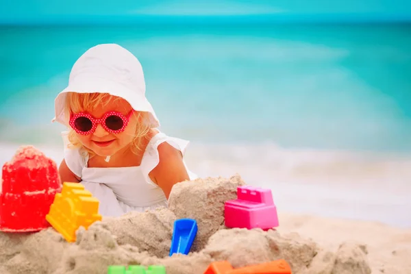 Schattig klein meisje spelen met zand op het strand — Stockfoto