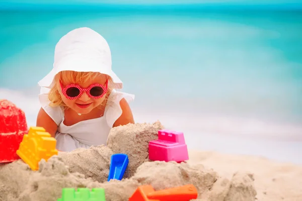 Schattig klein meisje spelen met zand op het strand — Stockfoto