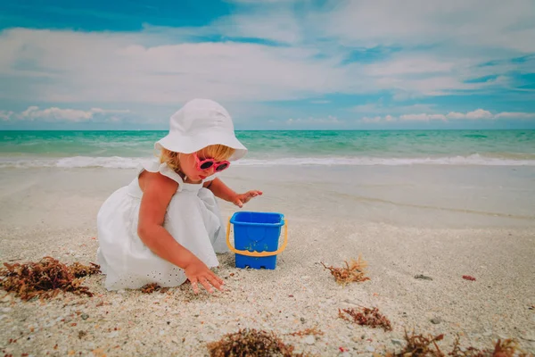 Carino bambina giocare con sabbia sulla spiaggia — Foto Stock