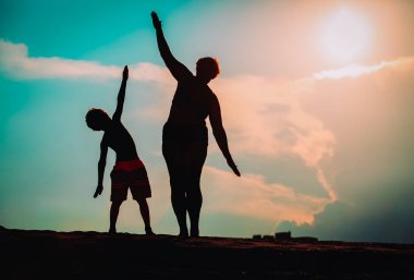 Günbatımı gökyüzü aile oynayan silüeti