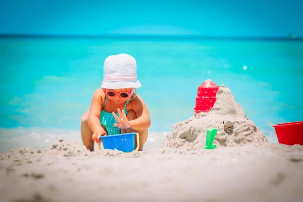 Cute little girl grać z piasku na plaży — Zdjęcie stockowe