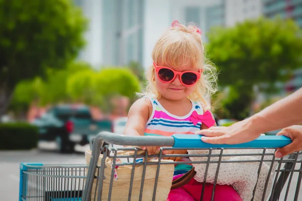 Shopping avec des enfants- mignonne petite fille dans le panier dans la ville — Photo