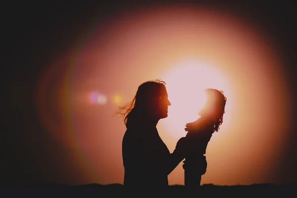 Happy mother and little daughter at sunset — Stock Photo, Image