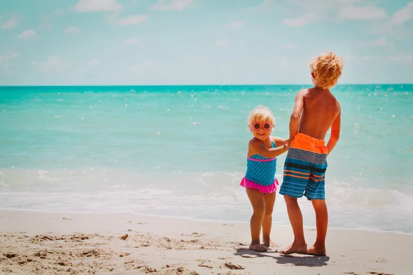 Gelukkig jongen en meisje spelen op strand vakantie — Stockfoto