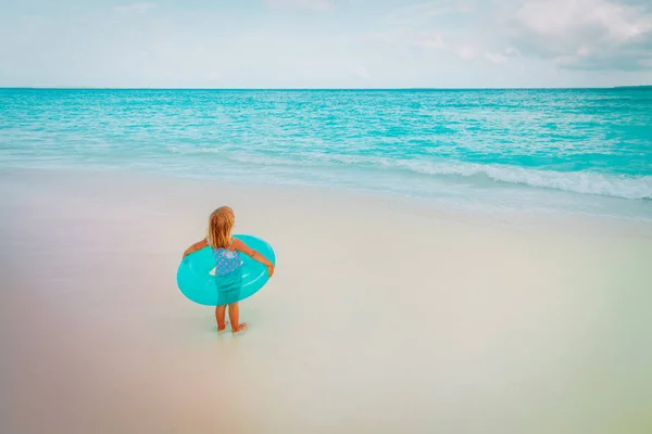 Linda niña con anillo de vida inflable ir a nadar en la playa —  Fotos de Stock