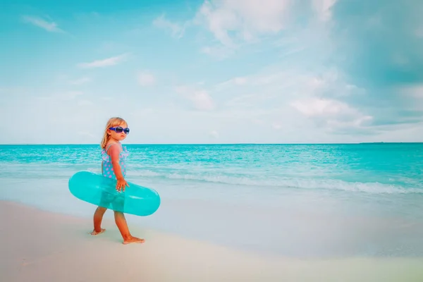 Linda niña con anillo de vida inflable ir a nadar en la playa —  Fotos de Stock