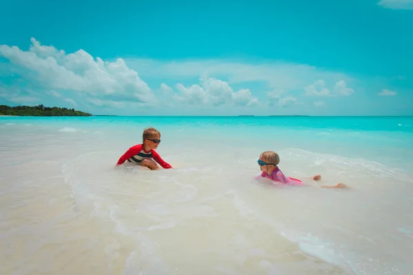 Menina e menino jogar natação na praia, as crianças brincam de férias — Fotografia de Stock