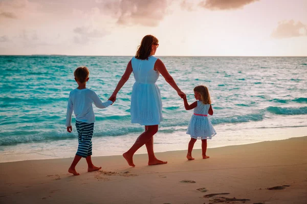 Madre y dos niños caminando en la playa — Foto de Stock