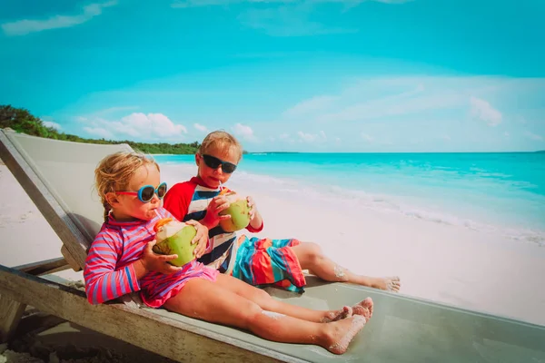 Bambino e ragazza bere cocco sulla spiaggia — Foto Stock