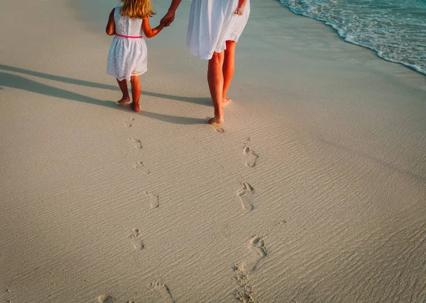 Mutter und Kinder gehen am Strand spazieren und hinterlassen Fußabdrücke im Sand — Stockfoto