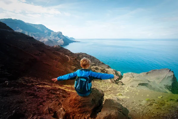 Lycklig pojke med ryggsäck vandring i berg till sjöss — Stockfoto