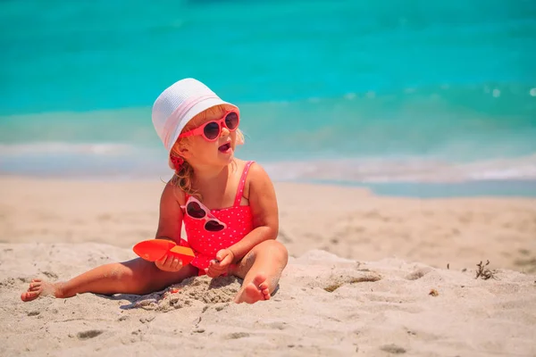 Bonito menina jogar com areia na praia — Fotografia de Stock