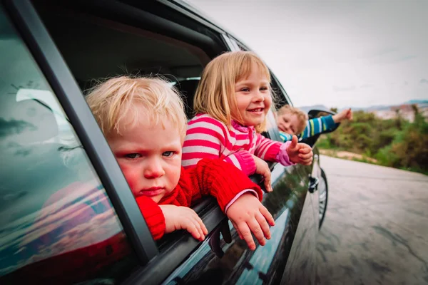 Cute dzieci podróżować samochodem na drodze w przyrodzie — Zdjęcie stockowe
