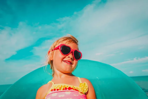 Mignonne petite fille avec jouet anneau flottant à la plage — Photo