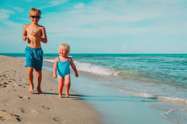 Klein meisje en jongen hebben plezier op het strand, kinderen genieten van vakantie — Stockfoto