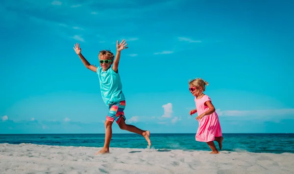 Felice bambino e ragazza giocare e saltare sulla spiaggia — Foto Stock