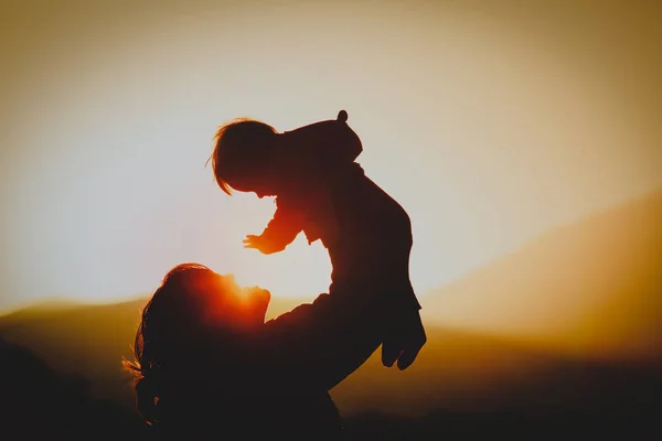 Mãe e pequeno bebê brincam ao pôr do sol natureza — Fotografia de Stock