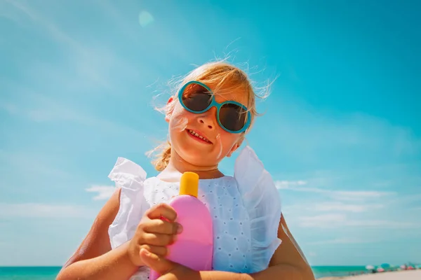 Conceito de proteção solar - menina bonito com protetor solar na praia — Fotografia de Stock