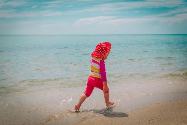 Bambina giocare con l'acqua in vacanza al mare — Foto Stock