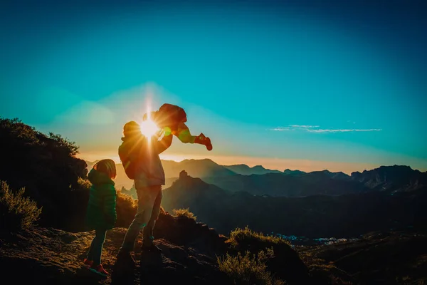 Otec a děti se baví cestovat v horách Sunset — Stock fotografie