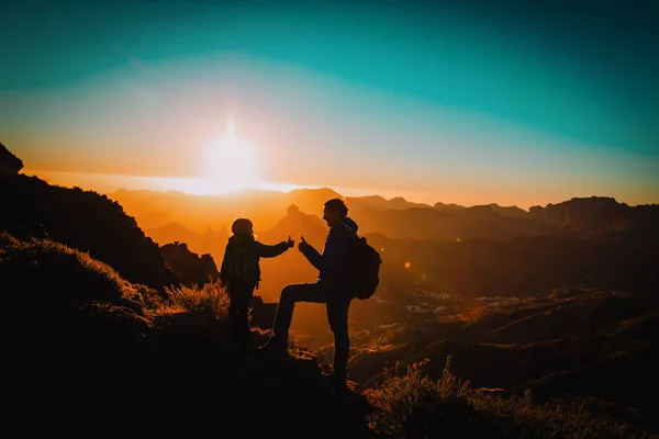 Отец и маленькая дочь путешествуют в горах на закате — стоковое фото