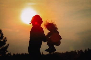 gün batımı gökyüzünde mutlu anne ve küçük bebek oyun