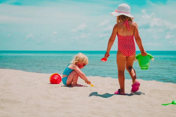 Niñas lindas juegan con arena en la playa de verano —  Fotos de Stock